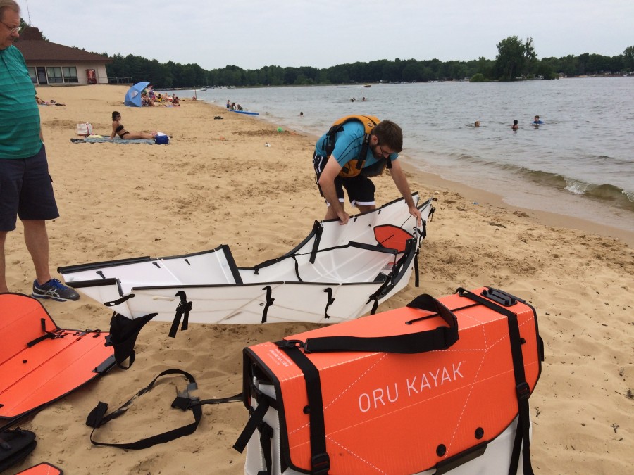 Photo of Oru Kayaks being folded on the beach.